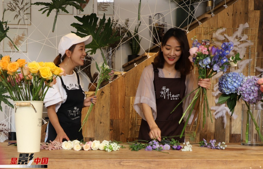 “昆明是鮮花的原產(chǎn)地，有亞洲最大的鮮切花交易市場，可以說具備開花店的天時地利；另外和很多女孩一樣，我從小也就有開花店的夢想！”說起當初的決定，王黎媛說一是因為夢想，另外也跟昆明這個城市產(chǎn)花、賣花的“基因”有關(guān)。圖為王黎媛和同事在制作花束。新華網(wǎng) 周亞平/攝 念新洪/文